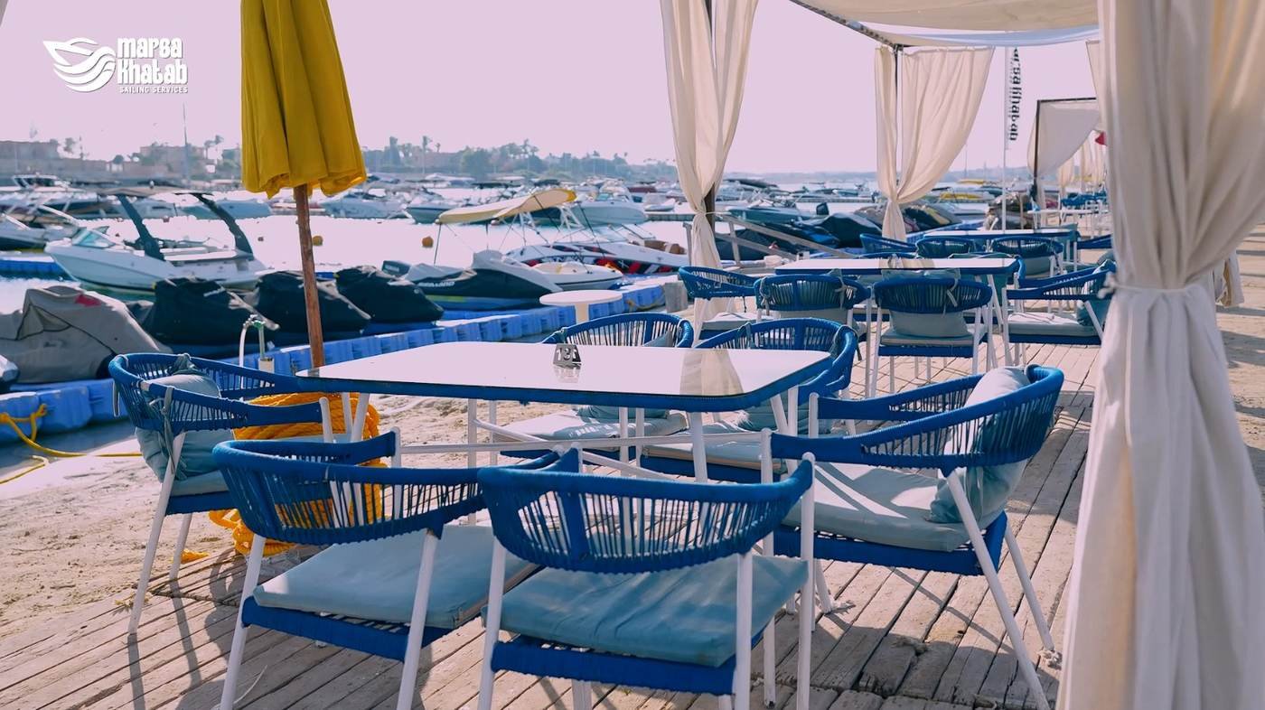Close view of blue woven lounge chairs and tables at the marina