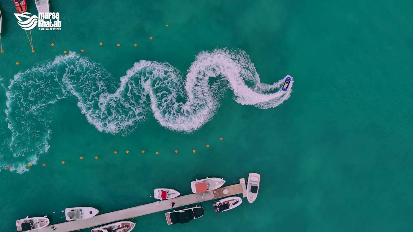 Jet ski carving wake patterns across turquoise water
